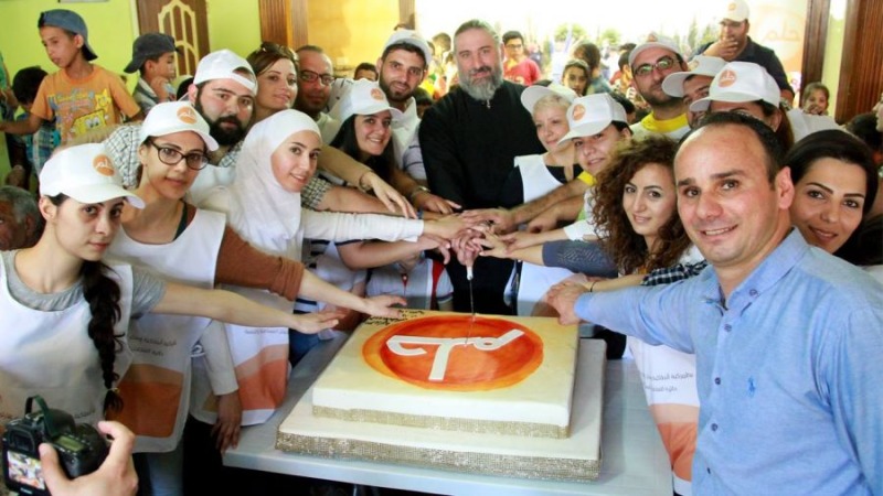 Główni organizatorzy projektu nad tortem z logo akcji, którym jest napis "Hulm"